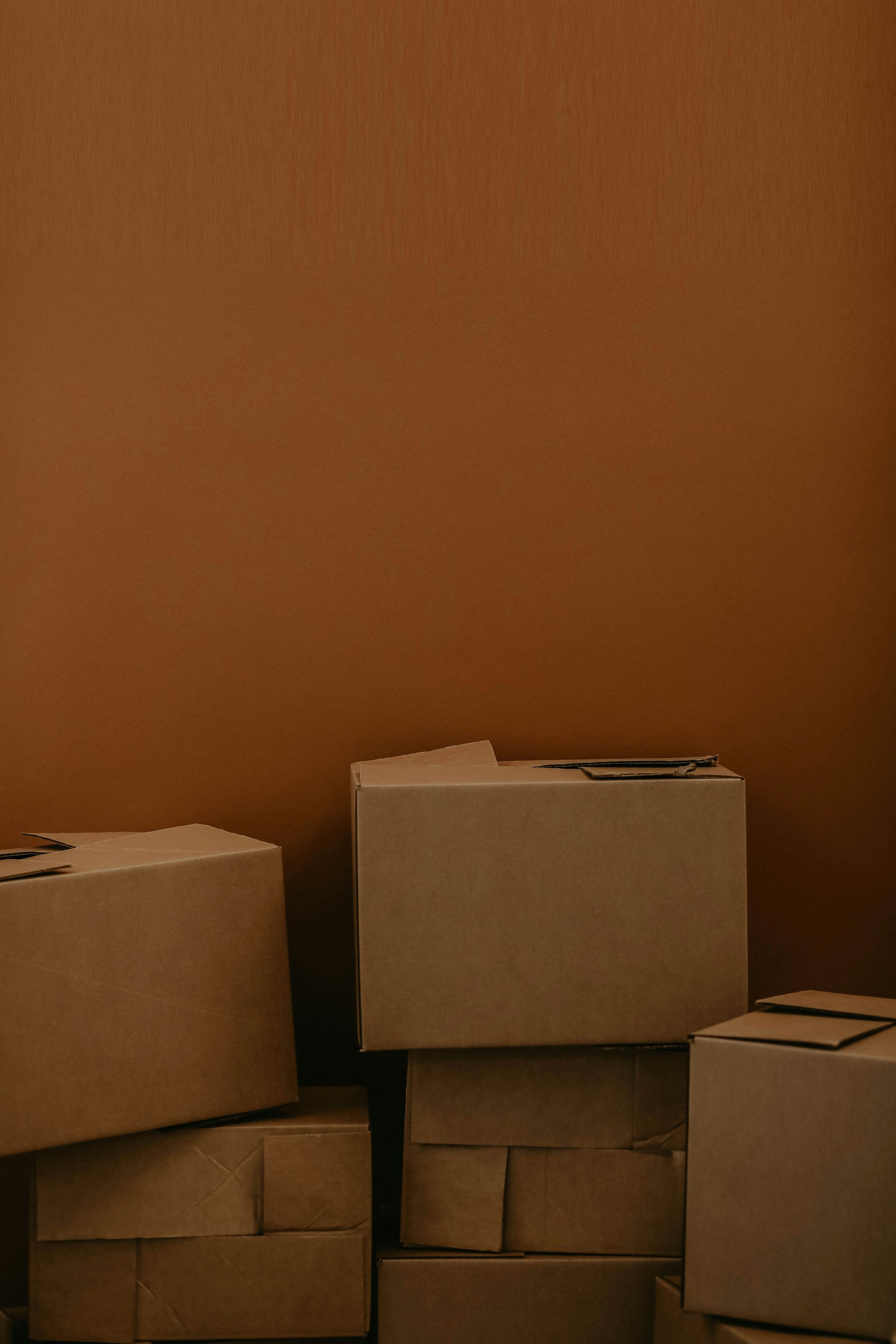 A stack of brown cardboard boxes against a solid brown background
